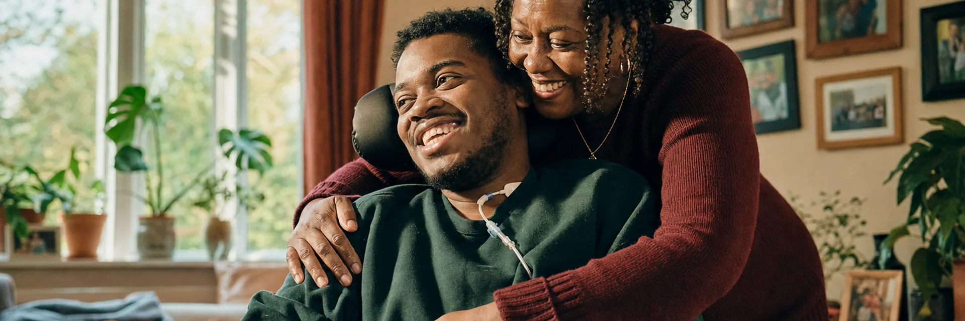 An adult son embraces his elderly mother at home