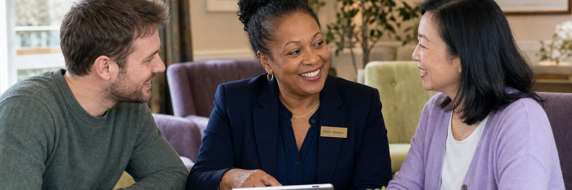 A residential care home manager meeting with two staff members in a common area